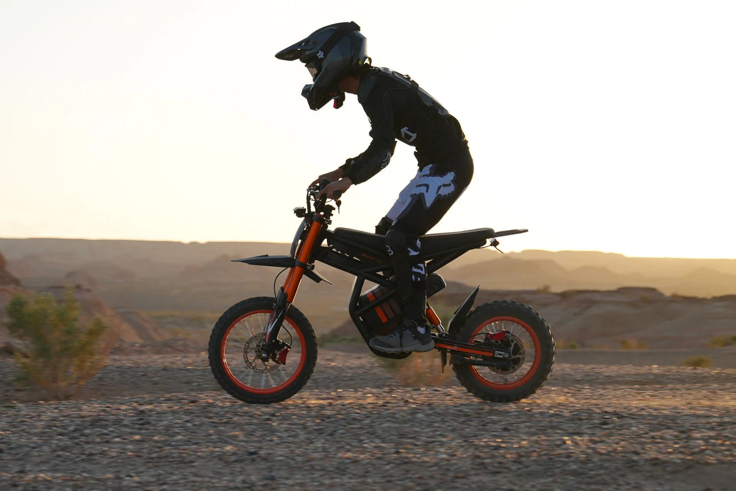 Riding’times GT54 with a helmeted rider on an off-road trail at sunset