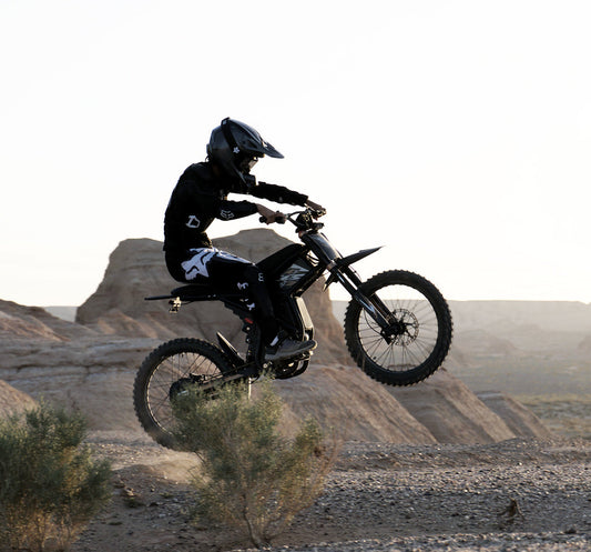 E-bike rider jumping on rocky terrain demonstrating terrain impact on e-bike riding time and battery life