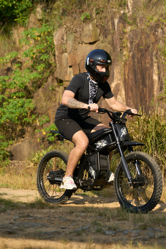 Rider on a black Riding Times e-bike demonstrating terrain performance on an off-road dirt trail