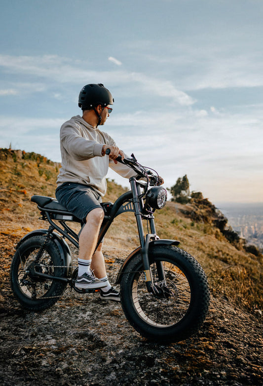 Man wearing helmet riding Riding Times Z8 EBIKE on rocky terrain at sunset