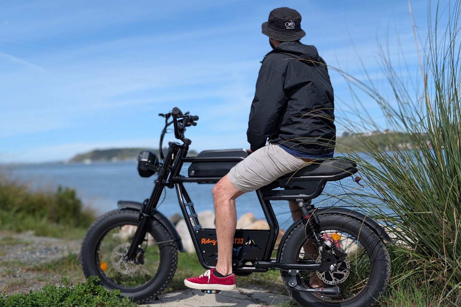 Riding Times GT33 all-terrain cargo electric bike ridden at a coastal waterfront, overlooking the water on a sunny day