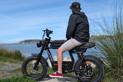 Riding Times GT33 all-terrain cargo electric bike ridden at a coastal waterfront, overlooking the water on a sunny day