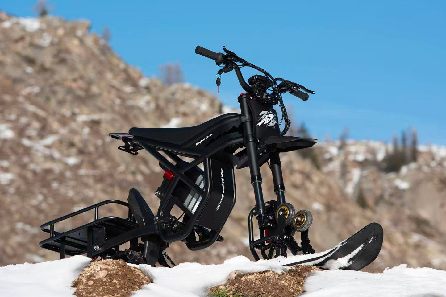 Black electric bike on a snowy landscape with mountains in the background