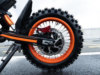 Close-up of GT54 electric mini motorbike rear wheel with orange rim and off-road tire