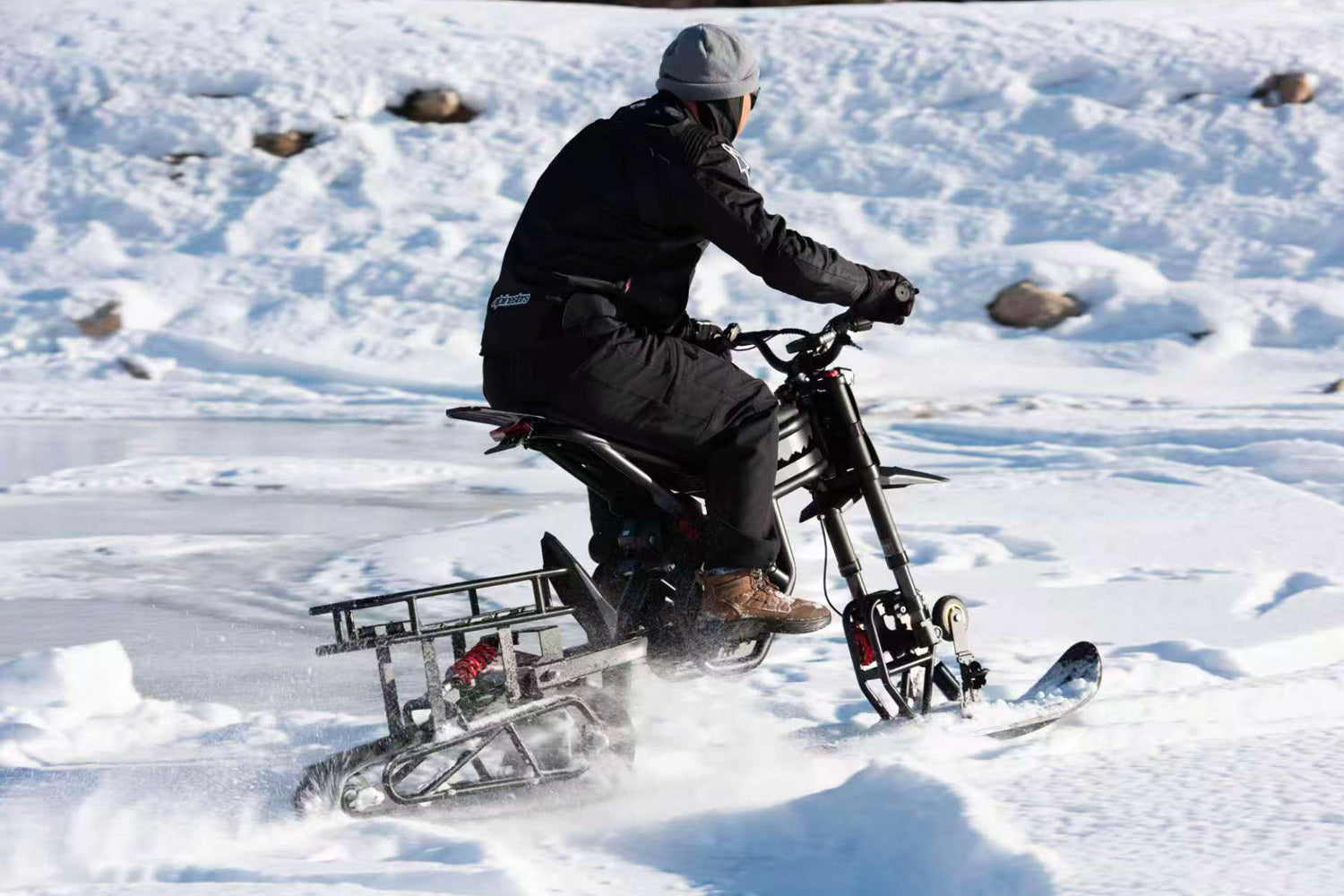 Person riding a snow bike on a frozen lake