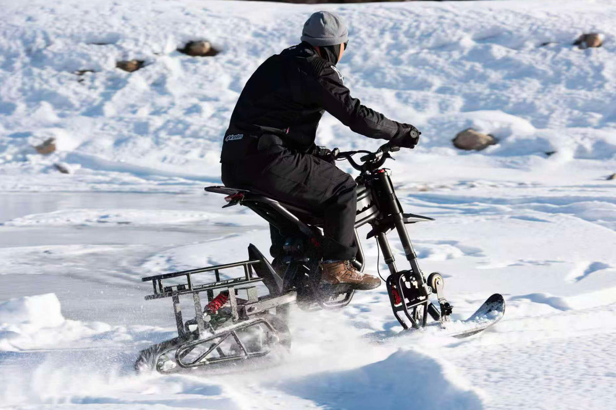 Person riding a snow bike on a frozen lake