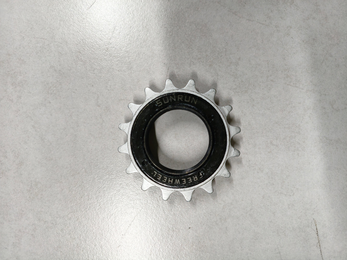 Metallic sprocket on a reflective gray surface