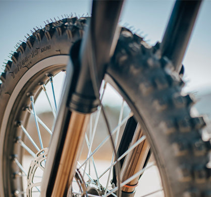 Close-up of durable front tire with reinforced rubber tread for improved grip and puncture resistance on various terrains