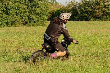 Person riding a balance Z8 in a grassy field with trees in the background