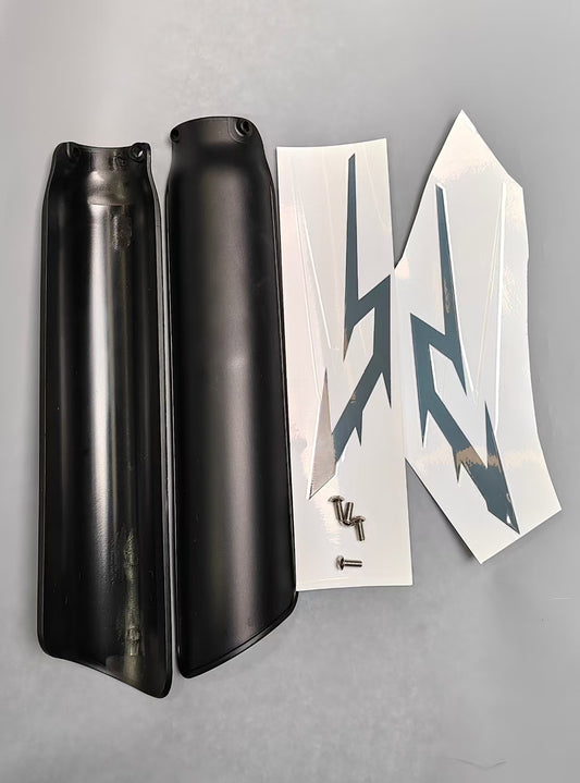 Black front fork guard covers with white graphic decals and mounting screws on gray surface